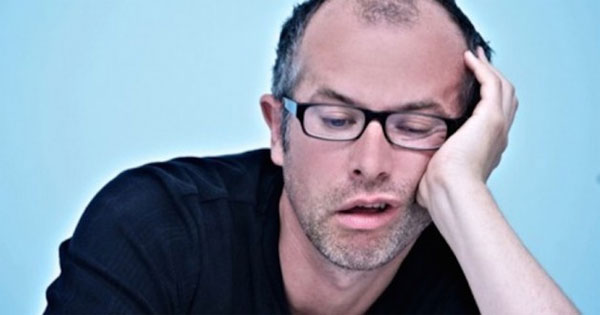 Person staring blankly out window feeling bored and unenthusiastic