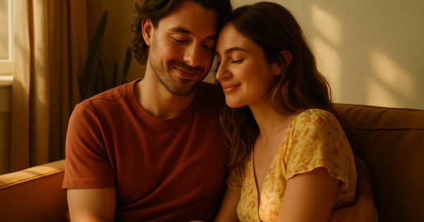 Couple laughing together on a sunny park bench
