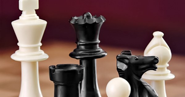 Dramatic wooden chess board with pieces in play
