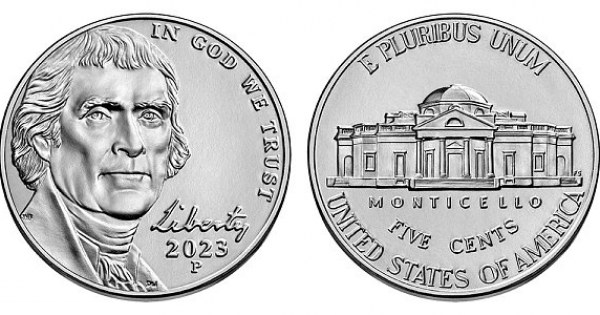 Thick silver nickel coin on stone surface in daylight.